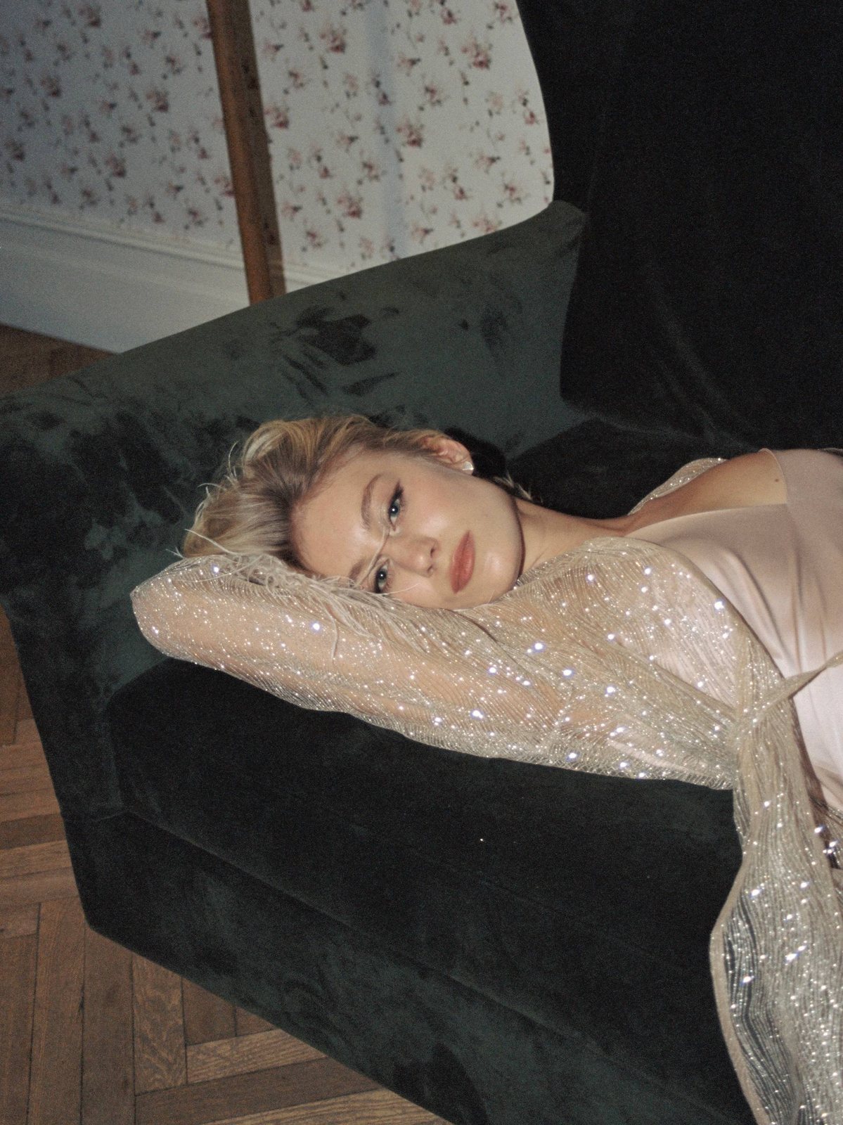 Ari resting on a green velvet sofa